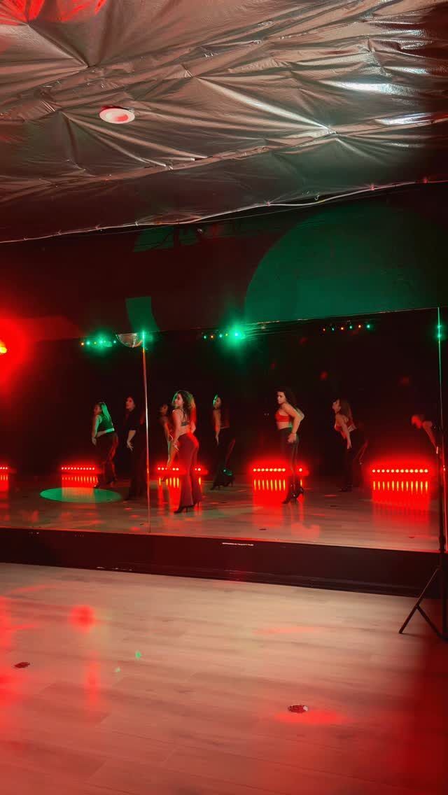 Dancers in a dark studio lit by red and green floor lights